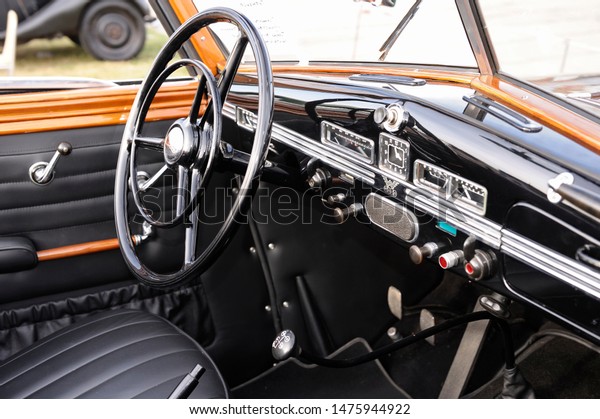Interior of an old car: steering wheel,\
dashboard, gear shift, glove compartment, seats. Festival OLD CAR\
Land. May 12, 2019. Kiev, Ukraine\
