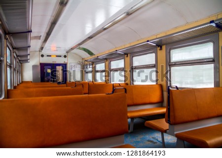 Interior of an old soviet style train with brown seats and winter scenery behind the window