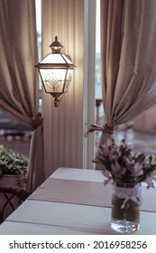 interior on restaurant veranda decorations with a lamp and a bouquet of flowers on the table