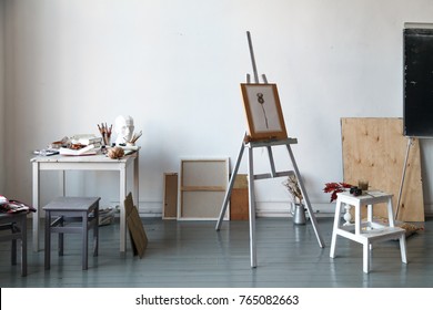 Interior of painting studio of freelance artist. Gypsum head, brushes, pencills, ink and paint bottles with sketchbooks on the table. Freelance artist lifestyle concept - Powered by Shutterstock