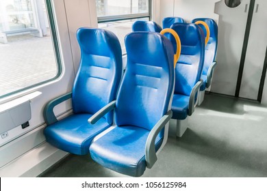 Interior of a passenger train with empty blue seats