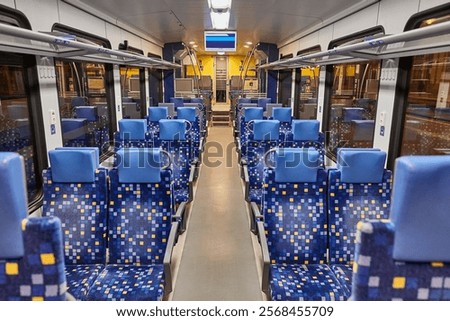 Interior of a passenger train with empty seats, no people during the night
