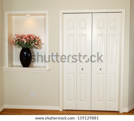 Interior photo of front closet and wall with decorated flower and light