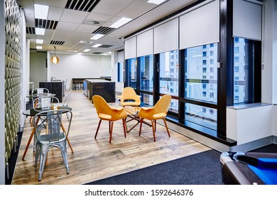 Interior Photography Of Commercial Fit Out Of Modern Office Break Out Area With Orange Chairs, Decorative Room Divider And Pool Table And Tables And Chairs With Kitchen And City Views In Background