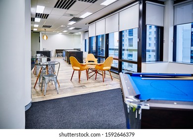 Interior Photography Of Commercial Fit Out Of Modern Office Break Out Area With Orange Chairs, Decorative Room Divider And Pool Table And Tables And Chairs With Kitchen And City Views In Background