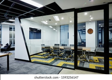 Interior Photography Of Commercial Fit Out Of Modern Design Board Meeting Rooms Surrounded By Glass Walls And Doors With Geometric Pattern Carpet, Wall Mounted Tv And Meeting Area To The Left