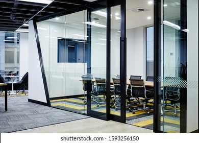 Interior Photography Of Commercial Fit Out Of Modern Design Board Meeting Rooms Surrounded By Glass Walls And Doors With Geometric Pattern Carpet, Wall Mounted Tv And Meeting Area To The Left