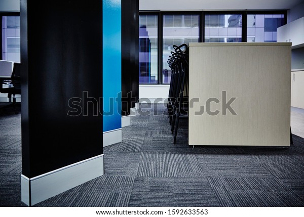 Interior photography\
of commercial fit out of office break out area with kitchen, modern\
graphic style room divider in black and teal and black stools at a\
tall bench table