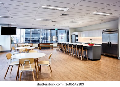 Interior Photography Of A Contemporary Design Corporate Office Break Out Area In A City Office Building With Kitchen, Breakfast Bar, Tables And Chairs On Polished Floor Boards