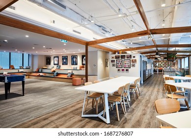 Interior Photography Of A Contemporary Design Corporate Office Break Out Area With Kitchen, Tables & Chairs And Games Room And Lounge On The Left