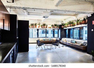 Interior Photography Of A Contemporary Design Corporate Office Break Out Area With A Kitchen, Banquette Seating And Pot Plants Displayed Above The Windows