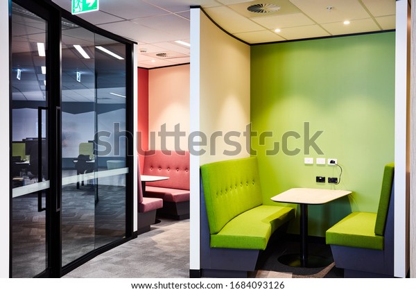 Interior photography\
of a contemporary design divided booth work spaces in lime green\
and pink with grey\
carpet