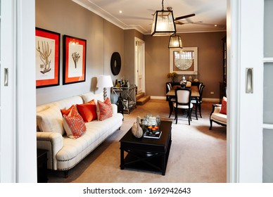 Interior Photography Detail Of A Hamptons Style Lounge And Dining Room With A Black And Taupe Decor, Couch, Coffee Table And A Dining Table Shot Through A Doorway