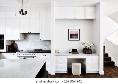 Interior Photography Of A Fresh White Kitchen And Home Office Area With Stairs On The Right