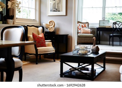 Interior Photography Of A Hamptons Style Formal Lounge Room With Wing Back Chairs, A Fireplace And A Sitting Room In The Background With Writing Desk And Arm Chairs