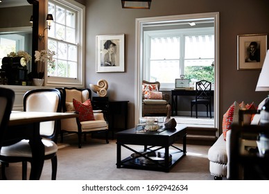 Interior Photography Of A Hamptons Style Formal Lounge Room With Wing Back Chairs, A Fireplace And A Sitting Room In The Background With Writing Desk And Arm Chairs