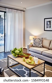 Interior Photography Of Hamptons Style Lounge Room With Cream Sofa, Framed Prints, Side Lamp And Table, Coffee Table And Rug