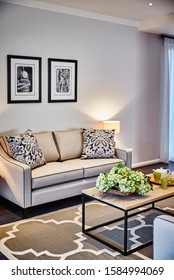 Interior Photography Of Hamptons Style Lounge Room With Cream Sofa, Framed Prints, Side Lamp And Table, Coffee Table And Rug With Decorator Items