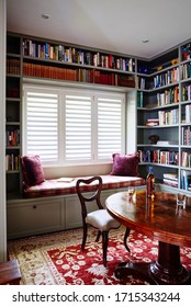 Interior Photography Of A Home Office/library Study Area With A Bay Window Banquette Seat And An Antique Timber Table And Chairs