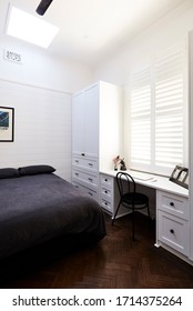 Interior Photography Of A Minimalist Modern Teenage Boy's Bedroom In A Renovated Home With A Built In Wardrobe, Storage And Desk, White Plantation Shutters