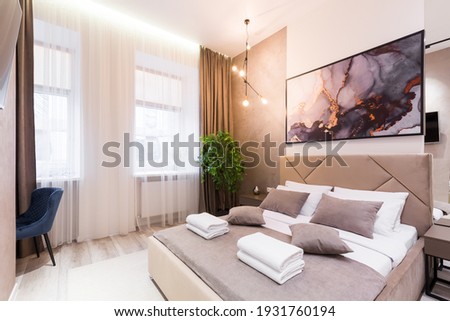 Interior photography, modern bedroom, with large stylish bed, modern design, in beige