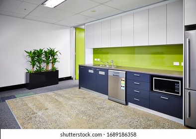 Interior Photography Of A Modern Corporate Office Break Out Area, An Office Kitchen With Grey And White Cabinetry, A Green Splash Back And Polished Concrete Floors