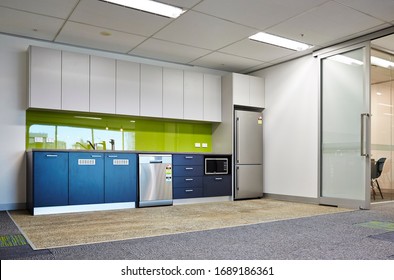 Interior Photography Of A Modern Corporate Office Break Out Area, An Office Kitchen With Grey And White Cabinetry, A Green Splash Back And Polished Concrete Floors