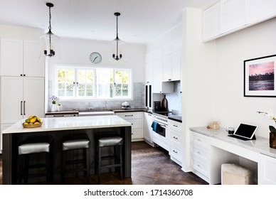 Interior Photography Of A Modern Hamptons Style Kitchen With A Marble Bench Top, Pendant Lighting And A Home Office Media Nook Area To The Right