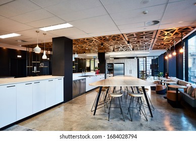 Interior Photography Of A Modern Office Breakout Area With A Kitchen, Timber Lunch Table, Laser Cut Wooden Ceiling, Polished Concrete Floors, Banquette Seating, Tables And Stools With A City View