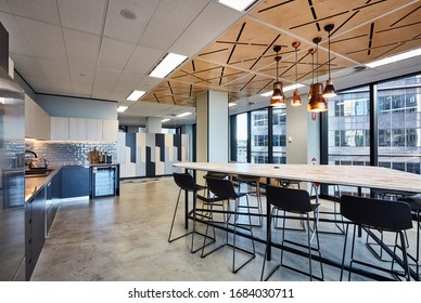 Interior Photography Of A Modern Office Breakout Area With A Kitchen, Timber Lunch Table, Laser Cut Wooden Ceiling, Polished Concrete Floors, Staff Lockers And Tall Windows With A City View