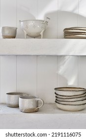 Interior Photography Of Open Shelving In A Boho Coastal Style Kitchen With White Painted V Groove Wall Panelling.