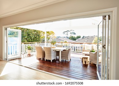 Interior Photography Of A Residential Timber Deck In A Coastal Style Home With Cane Furniture Table Setting