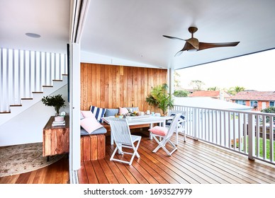 Interior Photography Of A Scandinavian Inspired Style Open Plan Living Area With Dining Table Opening Up To A Patio With Timber Decking And An Outdoor Furniture Setting