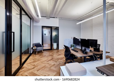 Interior Photography Of A Small Stylish Modern Corporate Office With Desks And A Parquetry Floor