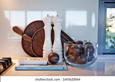 Interior photography still life detail of a cookbook, fruit bowl and homewares on a kitchen bench next to a stove