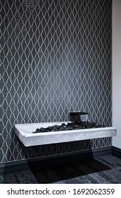 Interior Photography Of A Water Feature In A Corporate Office With Black Stones, A Concrete Finish Sink And A Grey Moroccan Pattern Tiled Wall