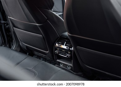 Interior Of A Premium Car. The Back Seat Of Prestige Luxury Modern Car. Black Leather And Rear Seat Air Conditioning Control Panel.