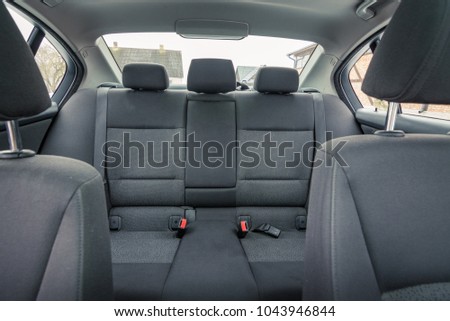 Interior of premium sedan car. Salon with seats, electronics, gauges, buttons, steering, mirrors and windows. Wooden panel and glass hatch.