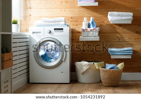 Interior of a real laundry room with a washing machine at the window at home