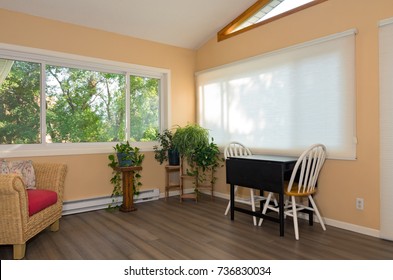 Interior Of Remodeled Sunroom Addition To Home And Decor Including Small Table With Chairs Bamboo Flooring And View From Window