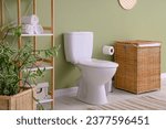 Interior of restroom with toilet bowl, shelf unit and basket