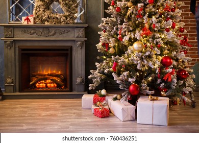 Interior Room Decorated In Christmas Style. No People. Home Comfort Of Modern House. Xmas Decorated Tree With New Year's Gifts Under And Burning Fireplace