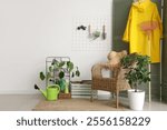 Interior of room with gardening tools, pin board and armchair