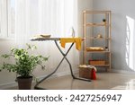 Interior of room with ironing board and laundry