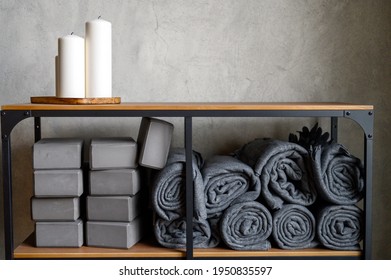 the interior of the room is a studio for sports yoga or stretching. table rack with decor candles and accessories for classes - gray support cubes, rubber mats and plaids