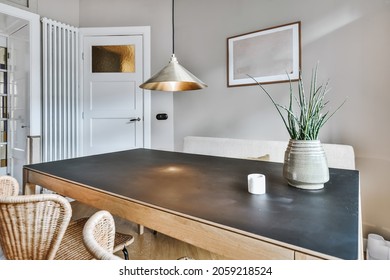 An Interior Shot Of A Dining Room Table With A Plant On Top As A Decoration Next To An Entrance