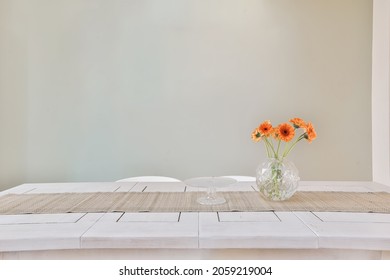 An Interior Shot Of A Dining Room Table With Flowers On Top As A Decoration