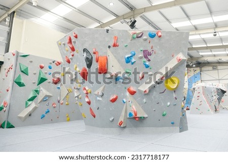 Interior shot of indoor climbing centre without people with assortment of colorful and challenging climbing walls