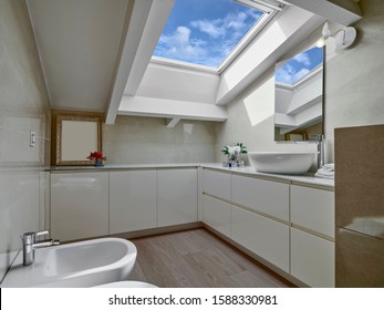 interior shot of a modern bathroom in the mansard with wood floor and the skylight
