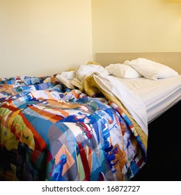 Interior Shot Of Motel Room With Messy Unmade Bed.